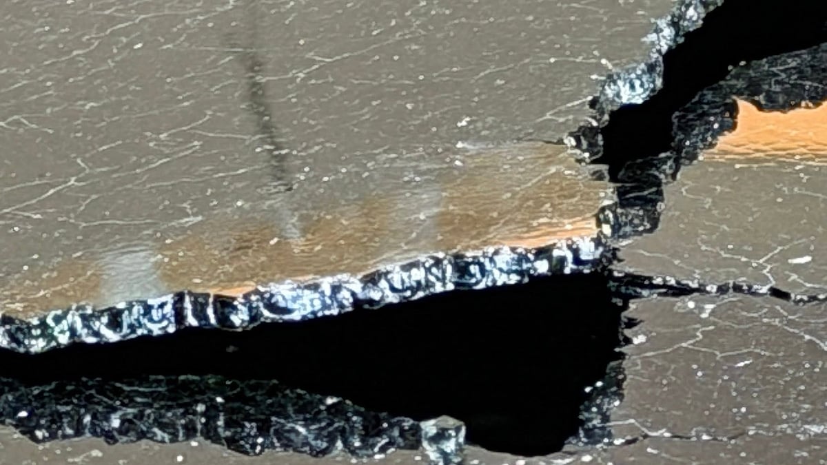 Close-up image of a cracked panoramic glass roof on Carrie's Kia Telluride, showing a large separation in the glass panel with fractured edges and visible cracking surrounding the damaged area.