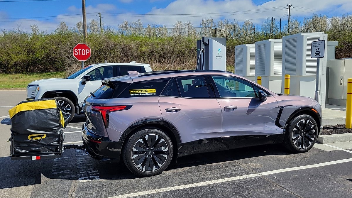 Christopher’s Chevrolet Blazer EV charging at an Electrify America station while towing a small cargo carrier.