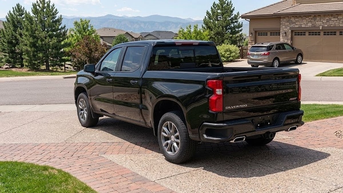 Black Chevrolet Silverado RST Crew Cab truck in a suburban Parker, Colorado driveway with Rocky Mountain views and stone-accented home