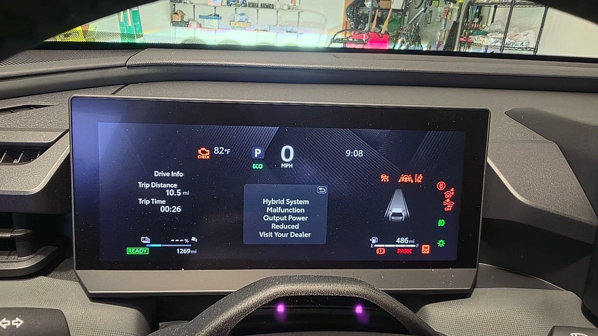 Vehicle infotainment screen showing a "Hybrid System Malfunction, Output Power Reduced, Visit Your Dealer" warning message