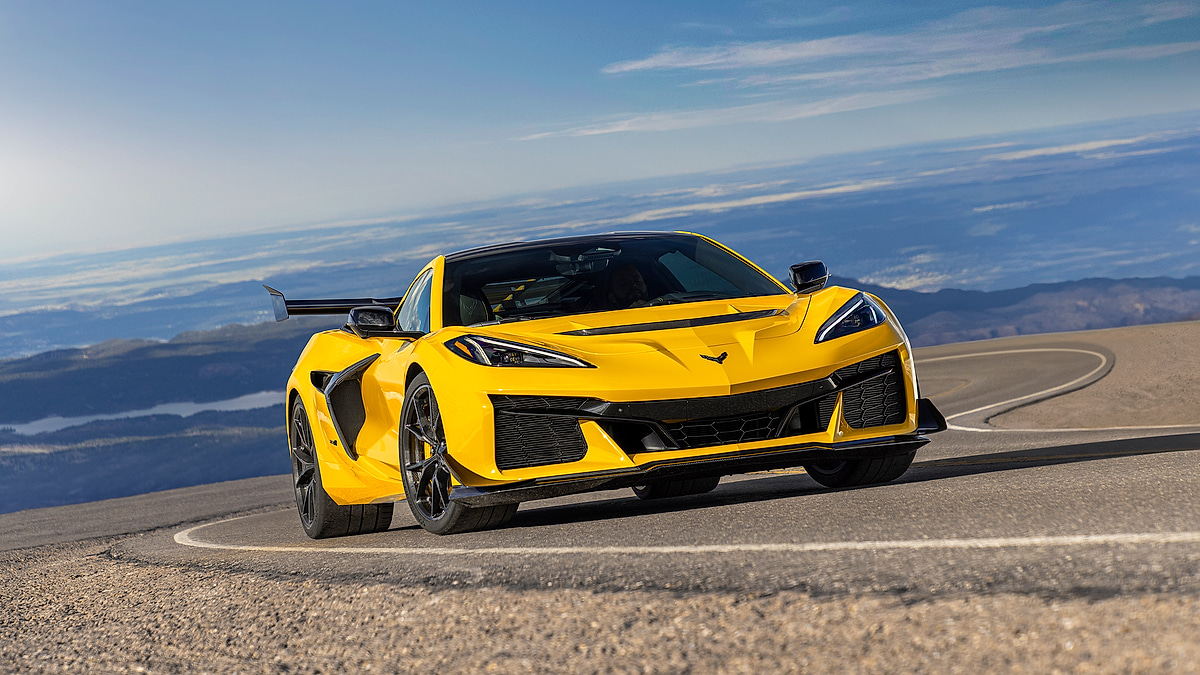Yellow Chevrolet Corvette C8 driving on winding mountain road