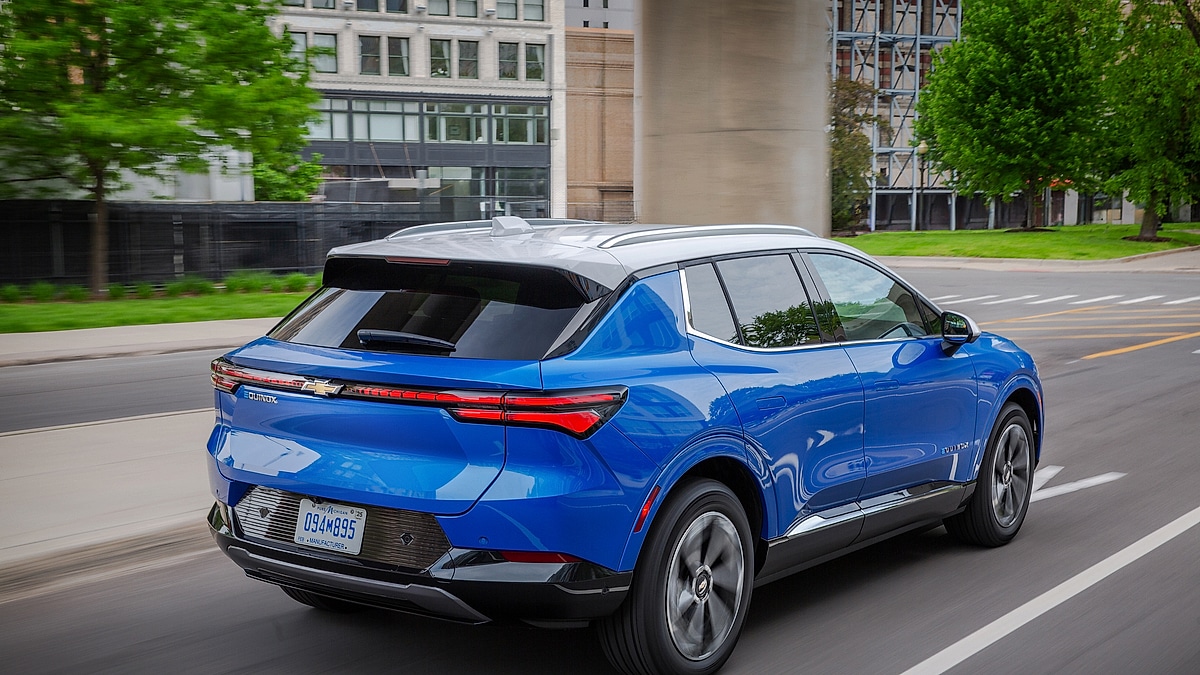 Chevrolet Equinox EV driving through city street rear view