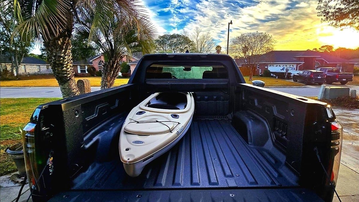 Gregg’s GMC Sierra EV Denali with a kayak loaded in the truck bed during a Florida sunset.