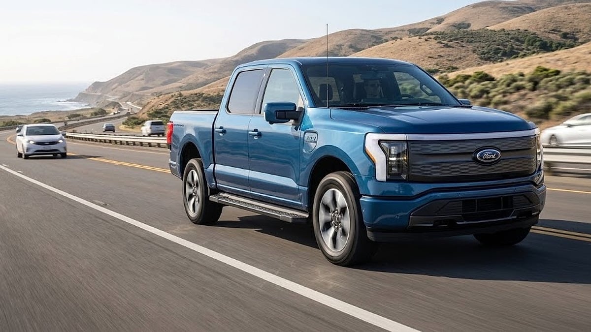 Compact Ford electric pickup truck cruising along a scenic California coastal highway during real-world range and high-speed efficiency testing