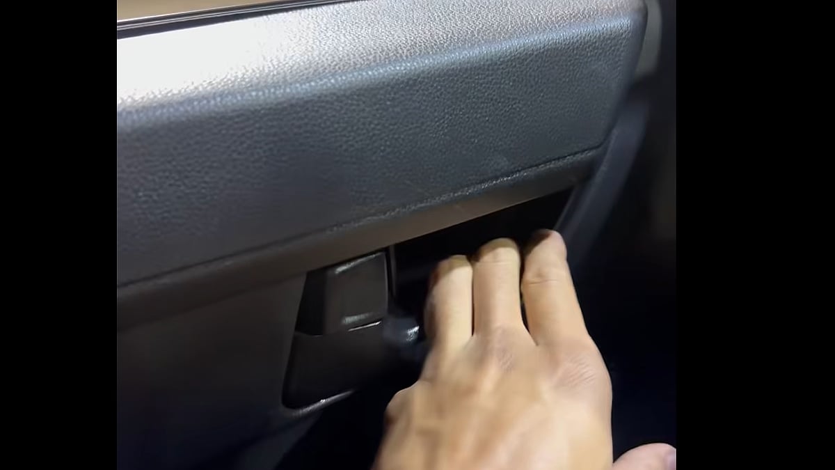 A 2025 Toyota Tacoma owner discusses a broken door handle claim with a service advisor inside a dealership service bay-optimized