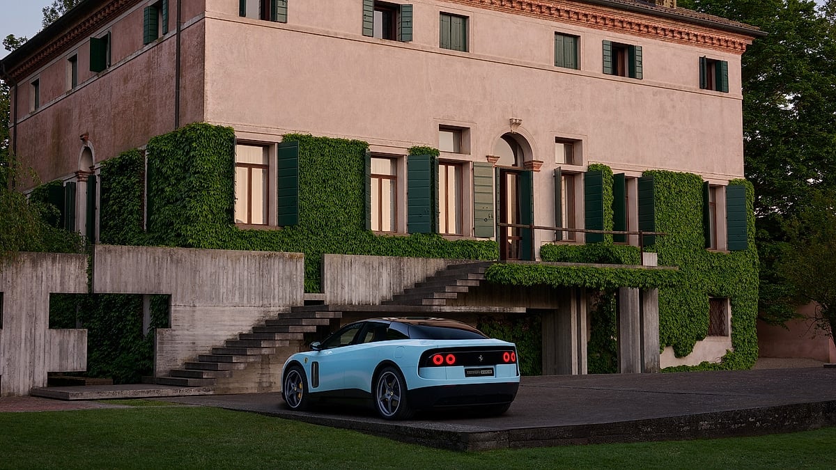 Blue Ferrari Luce shown from the rear three-quarter angle outside an ivy-covered villa.