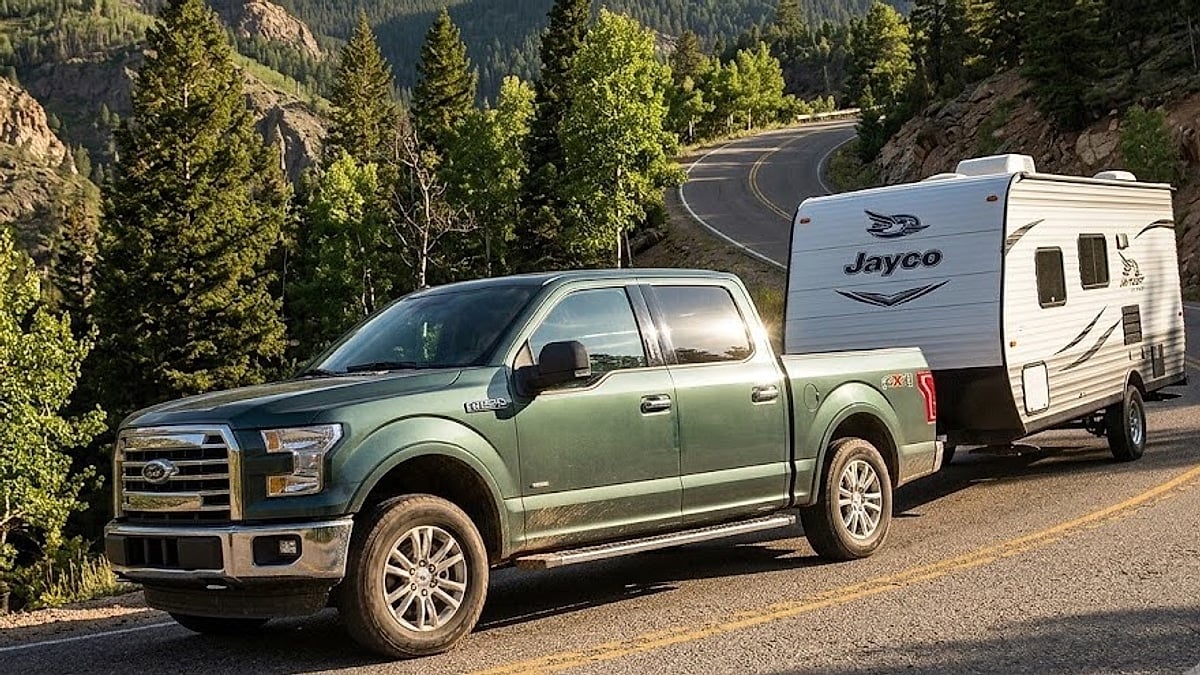Ford F-150 EcoBoost truck climbing a mountain road while towing a Jayco camper trailer