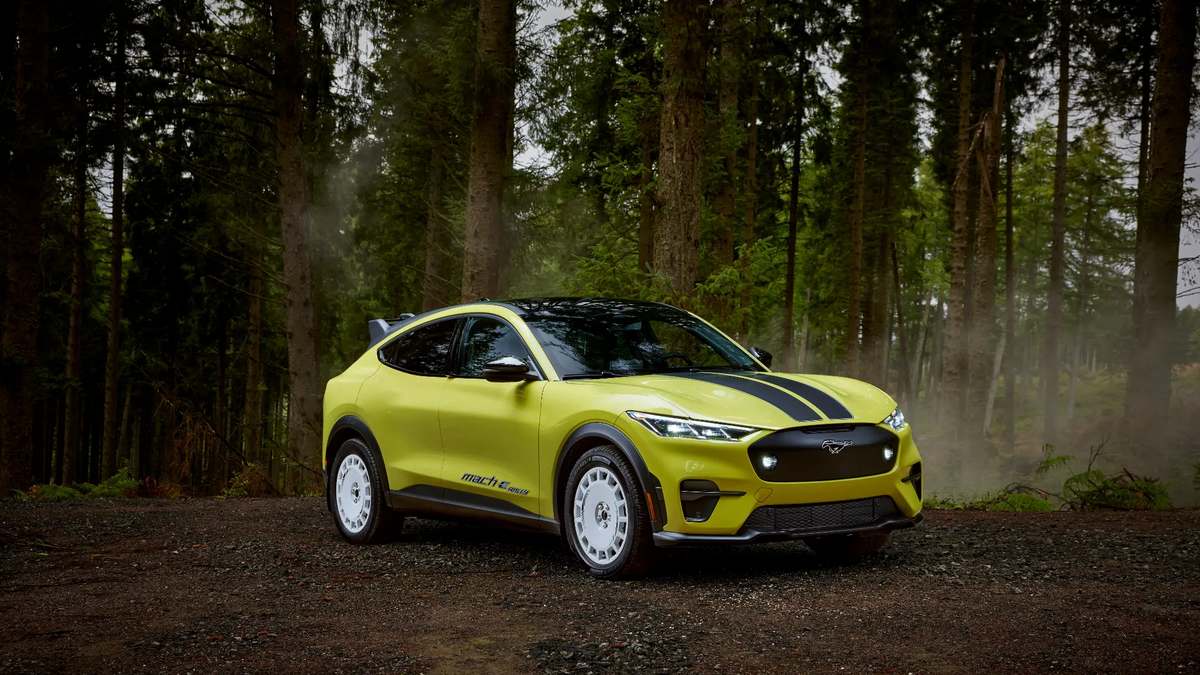 Yellow Ford Mustang Mach-E Rally electric SUV parked in a wooded forest setting