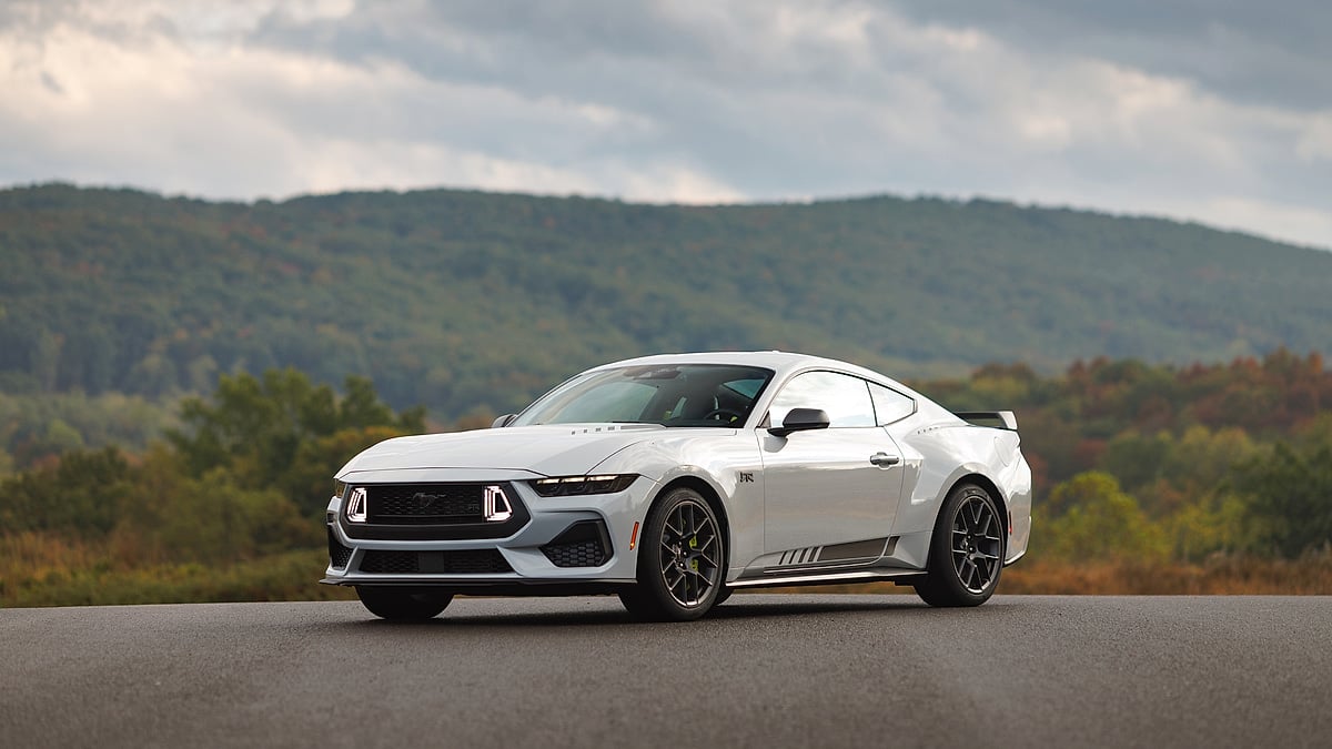 White Ford Mustang RTR Stage 3 package parked on road with fall foliage mountain backdrop, front three-quarter view