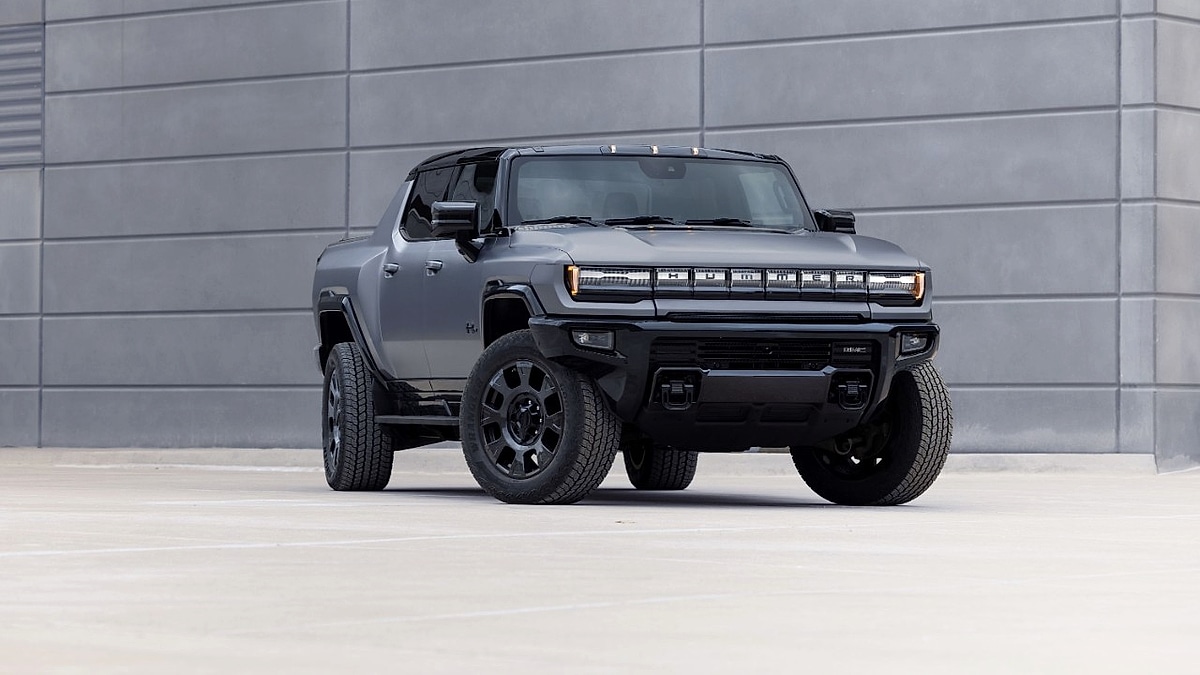 Gray GMC Hummer EV Carbon Fiber Edition parked in front of a modern concrete wall.