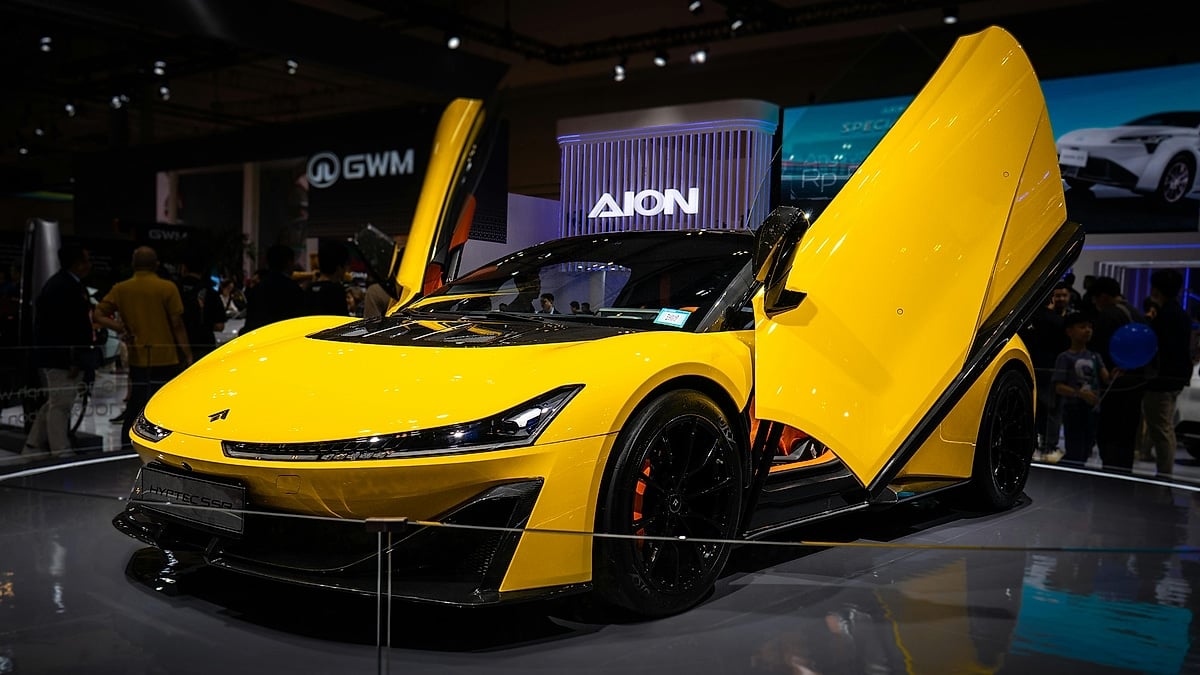 Yellow Hyptec SSR electric supercar displayed at an auto show with butterfly doors open.