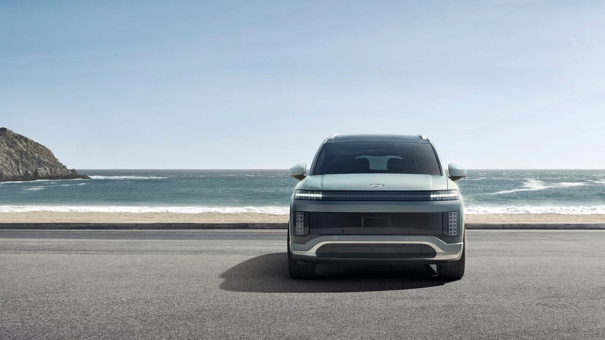 Front view of a Hyundai IONIQ 9 electric SUV parked by the ocean on a coastal road.