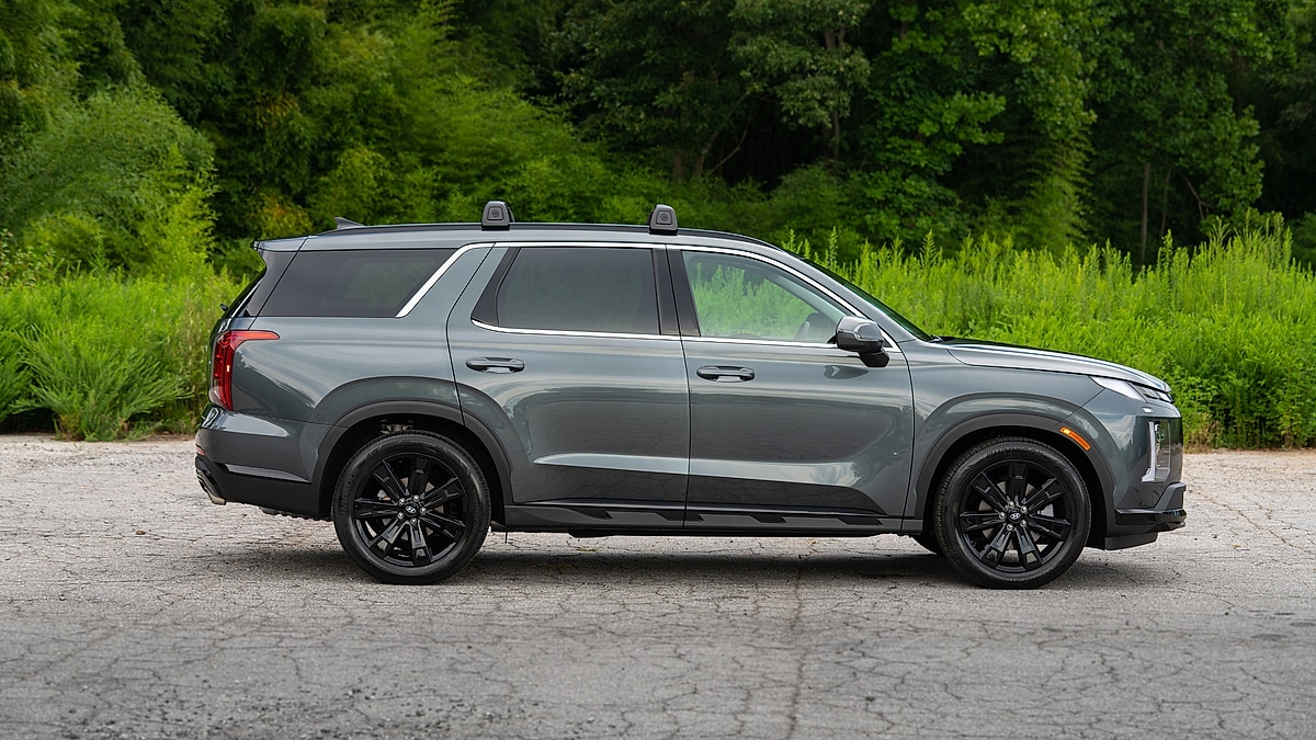 Hyundai Palisade XRT midsize SUV side profile parked on pavement with greenery background.