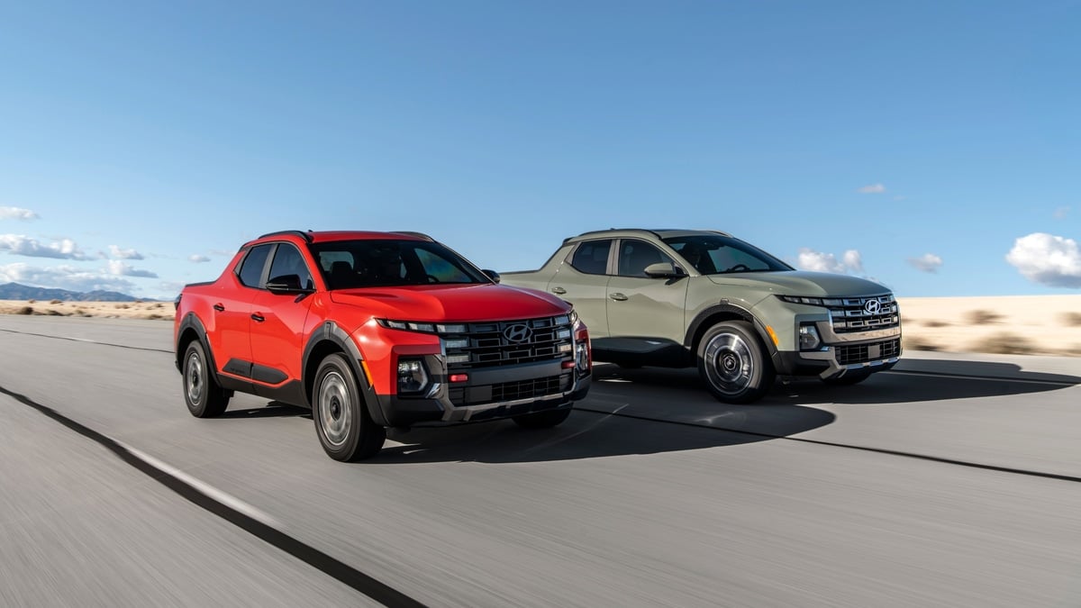 Two Hyundai Santa Cruz pickups in red, sage green driving together on a desert highway