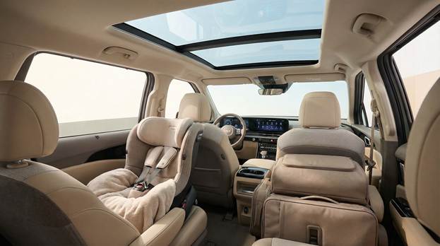 A captivating interior shot is taken from the second row, offering a detailed view of the 'Clearview Cockpit' featuring a stunning 34-inch curved screen and a transparent glass roof that floods the area with natural light. This inviting family setting includes a cozy child seat in the second row, surrounded by soft, neutral tones that enhance comfort. Luggage is neatly positioned in the rear, artfully arranged to demonstrate practicality and family adventures. The composition exudes warmth and functionality, encouraging viewers to imagine countless journeys shared together in this spacious and modern environment.
