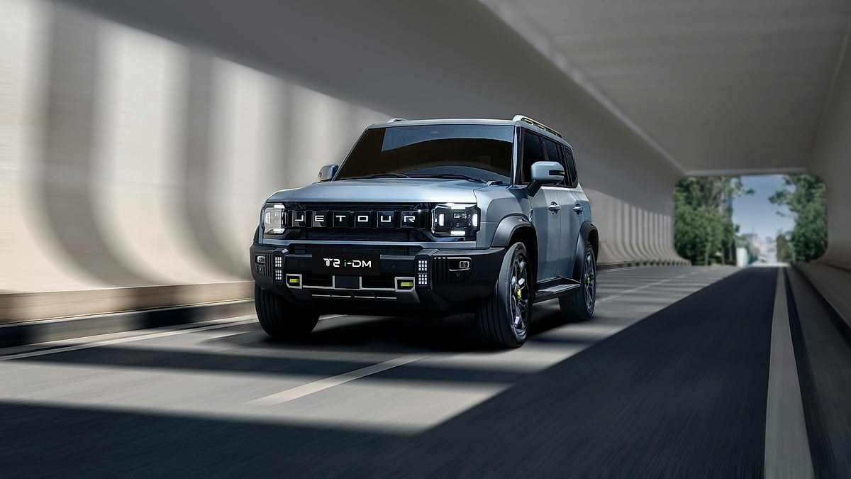 Jetour T2 i-DM SUV driving through a modern tunnel in a front three-quarter action view.