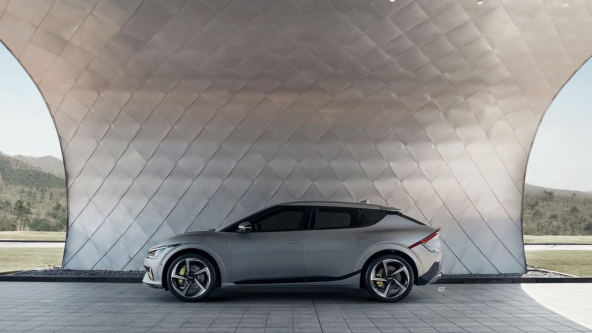 Gray Kia EV6 GT electric performance SUV side profile under futuristic architectural canopy