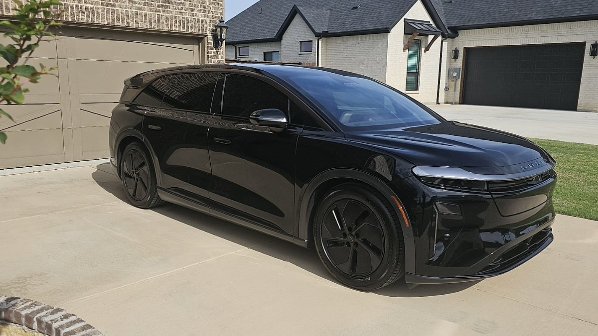 Black 2026 Lucid Gravity GT parked in a suburban driveway showing its sleek aerodynamic SUV design.