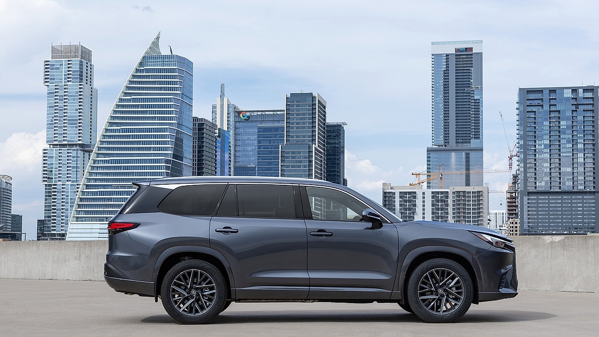 Gray Lexus TX SUV parked with city skyline behind
