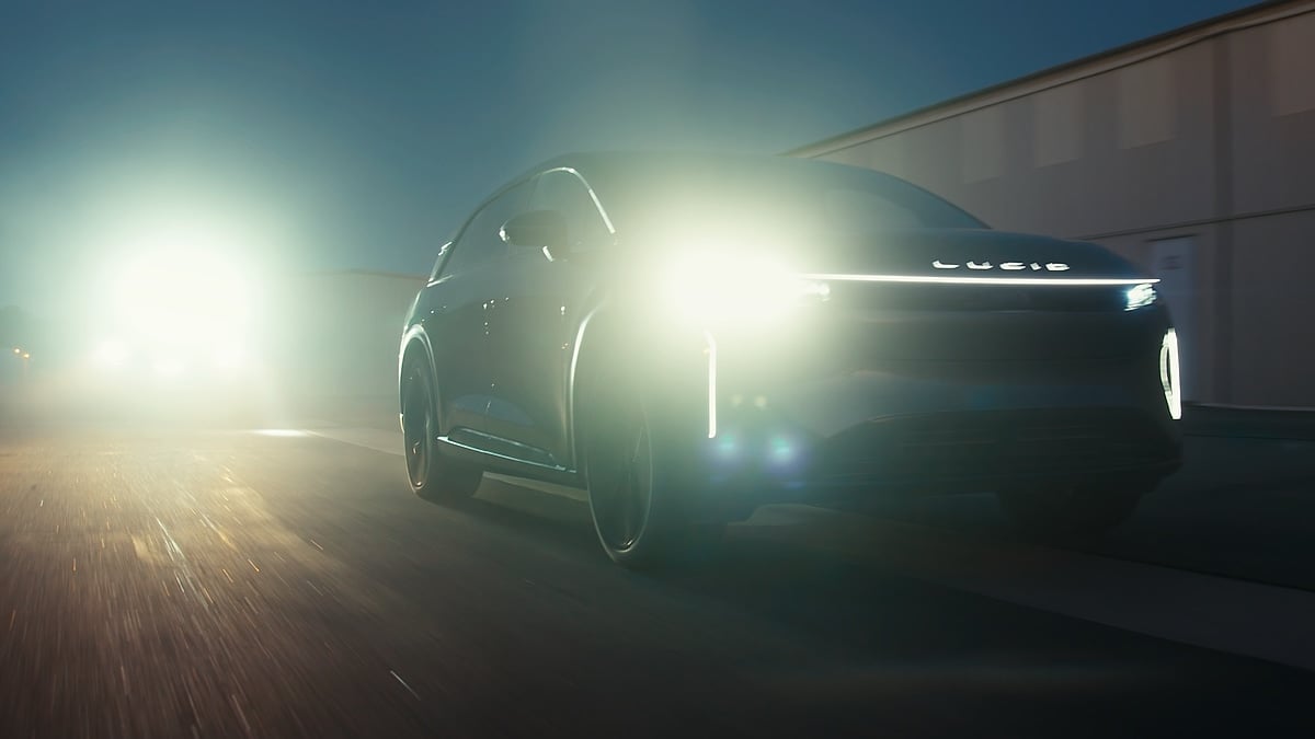 Lucid Gravity driving at night with bright headlights and LED light bar illuminated.