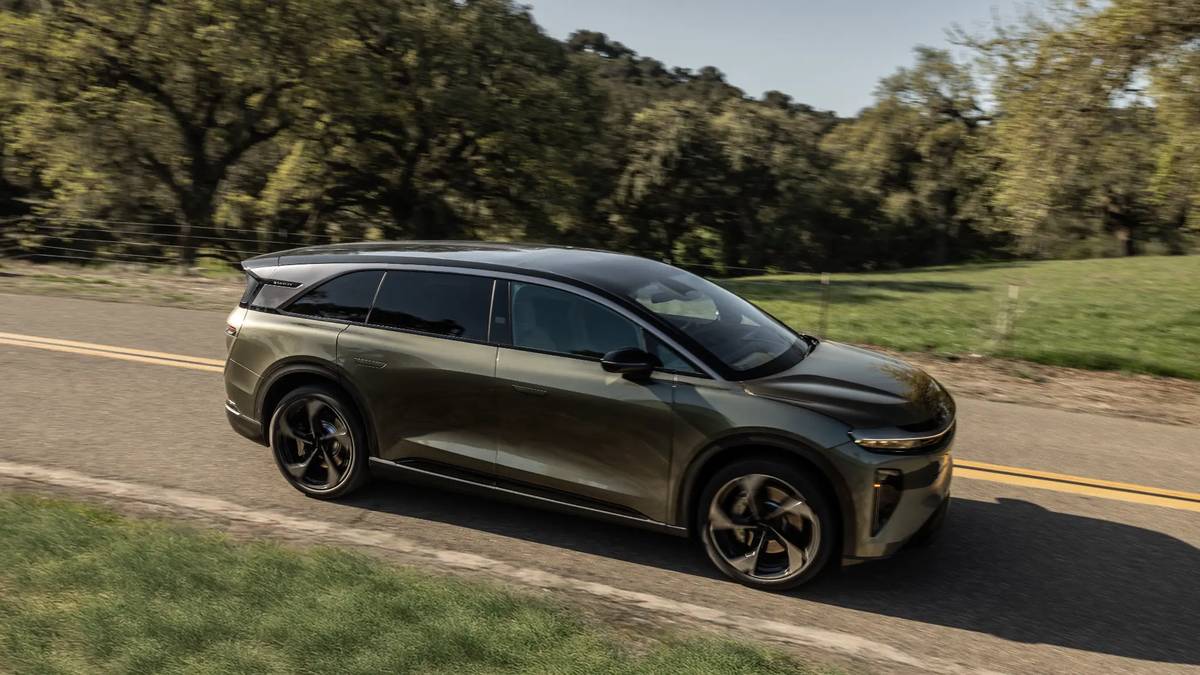 Olive green Lucid Gravity electric SUV driving on a country road
