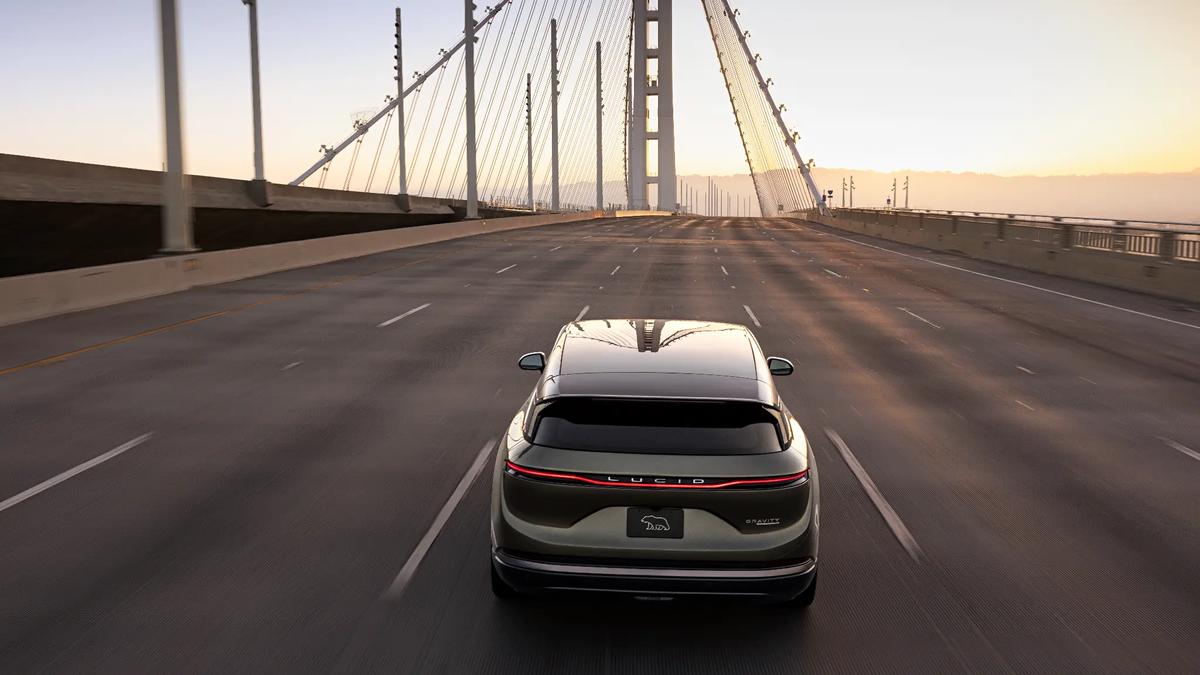 Rear view of Lucid Gravity electric SUV driving across a suspension bridge