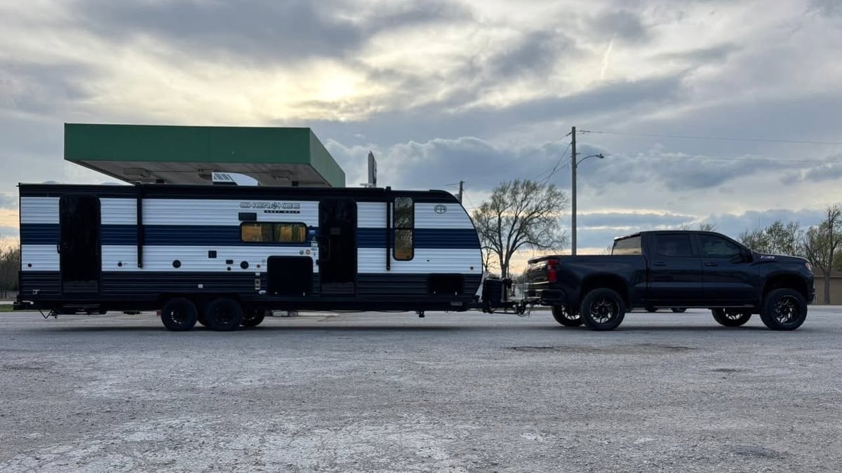 Lupe Herrera Jr.'s Chevy Silverado 2500 pulling a large travel trailer side view