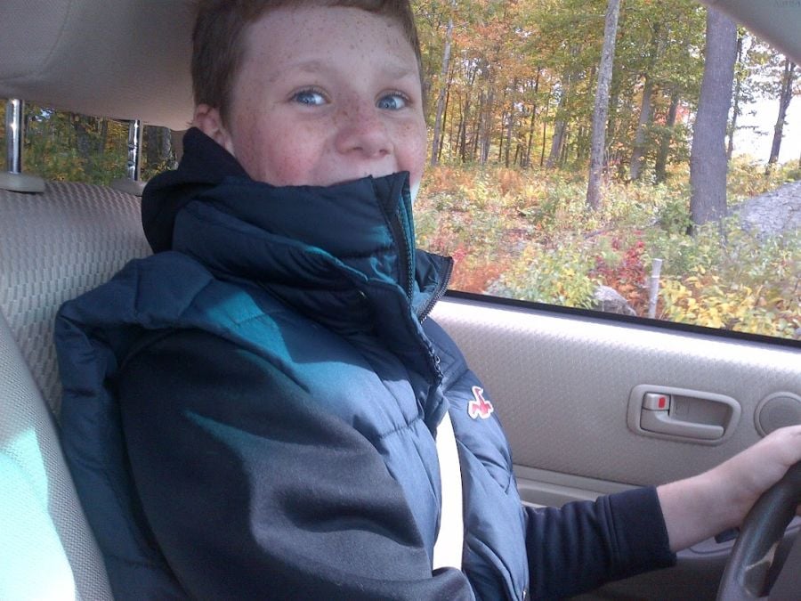 A young boy drives a Toyota Highlander on private property