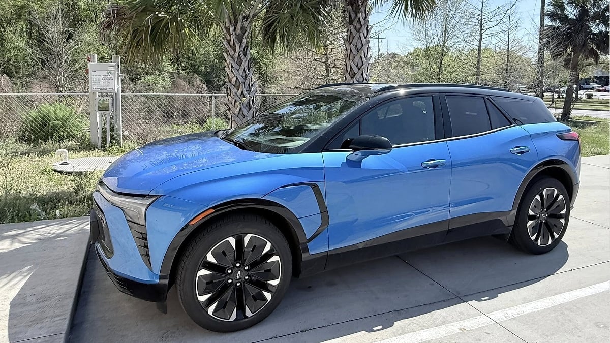 Michael's blue Chevrolet Blazer EV parked in a lot with palm trees in the background, highlighting its modern crossover styling.