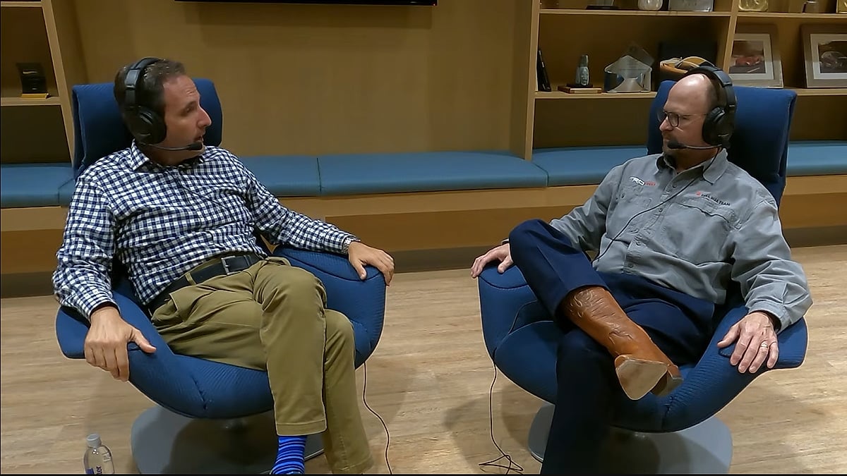 Two men wearing headsets sit in blue chairs during a Motoman podcast interview about Toyota trucks.