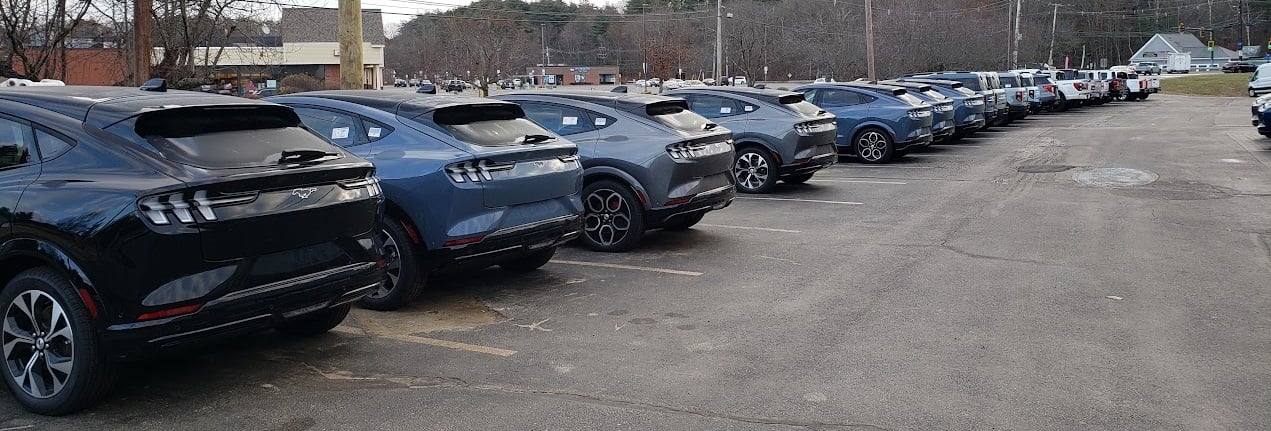 Image of 2024 Ford Mustang Mach-E cars in a line at dealership by John Goreham.