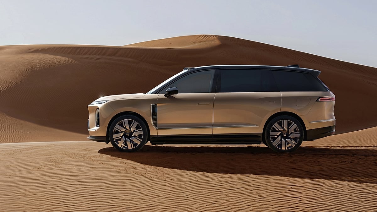 Gold Nio ES9 SUV in side profile parked on rippled desert sand dunes.
