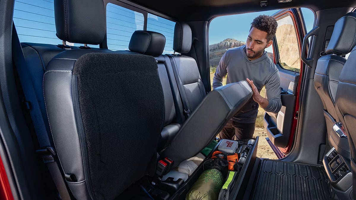 Rear seat storage compartment in a Ford F-150 showing under-seat cargo space for tools and gear.