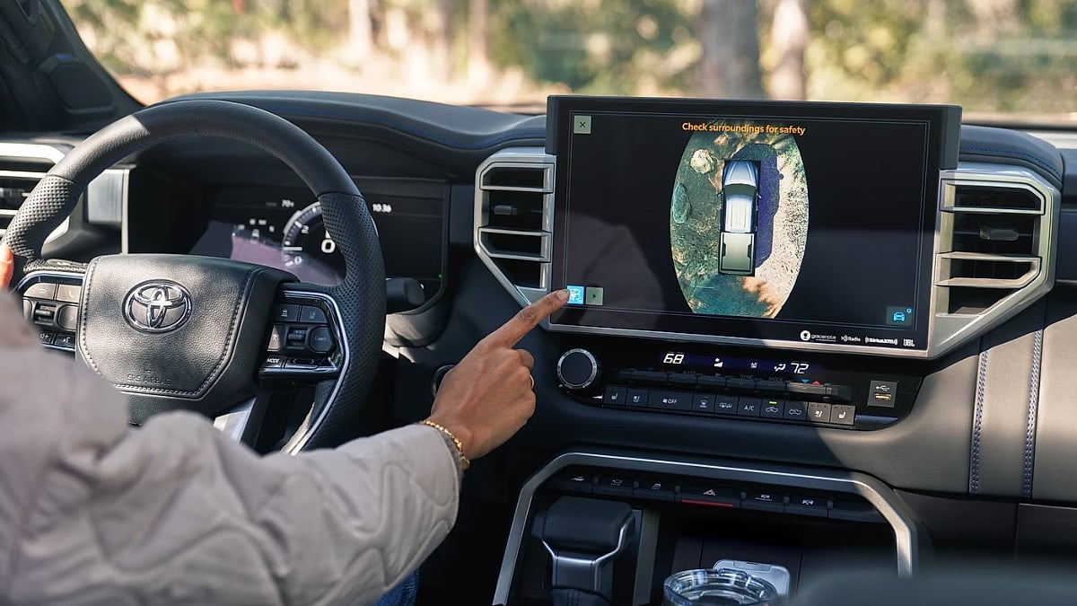 Driver using the 360-degree camera system and large infotainment display inside a 2026 Toyota Tundra pickup.