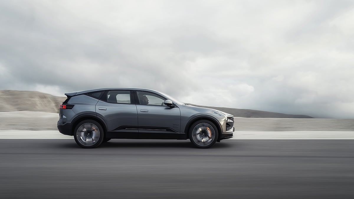 Gray Polestar electric SUV shown in side profile driving through a muted landscape under cloudy skies.