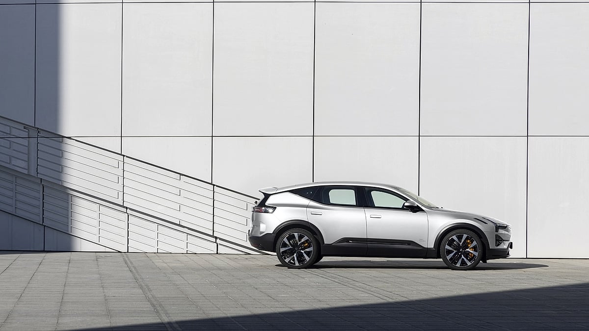  Silver Polestar 3 electric SUV side profile view parked against white architectural wall with dramatic shadow and yellow brake calipers