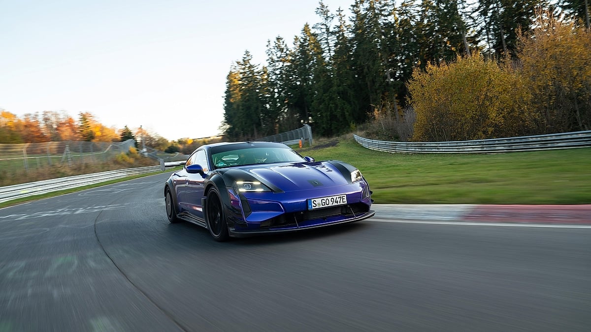 Purple Porsche Taycan Turbo GT with Manthey Kit driving on the Nürburgring in a front action view.