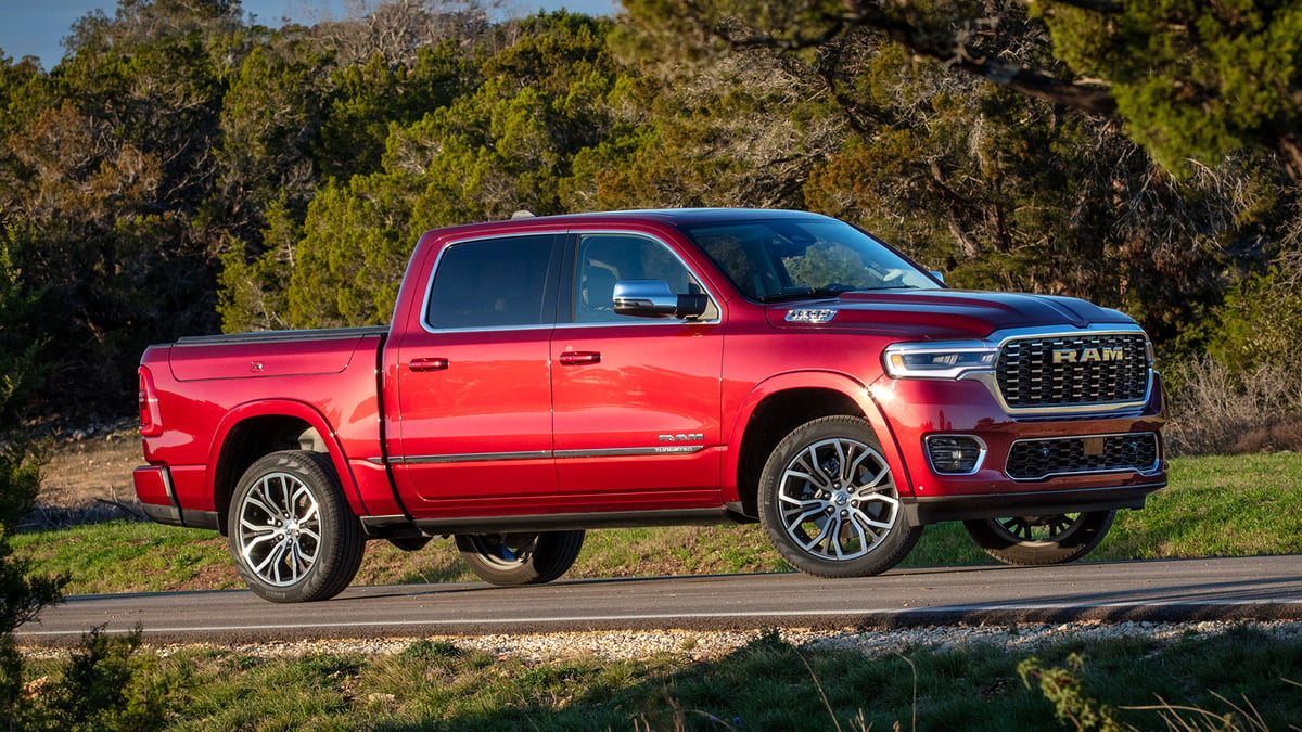 Red Ram 1500 Tungsten pickup truck parked on a rural road surrounded by trees, front three-quarter view