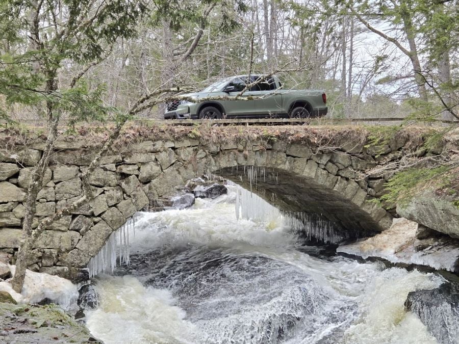 A 2026 Honda Ridgeline on a stone arch bridge above a flowing waterfall