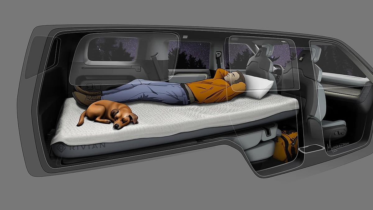 Rivian R2 interior concept illustration showing person and dog sleeping on flat-bed camping mattress under starry sky