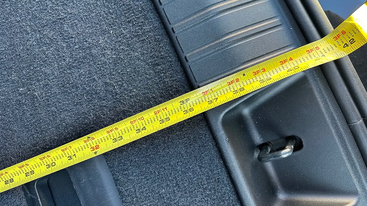 Close-up of Rivian R2 cargo area width measurement showing approximately 34 inches across the trunk floor.