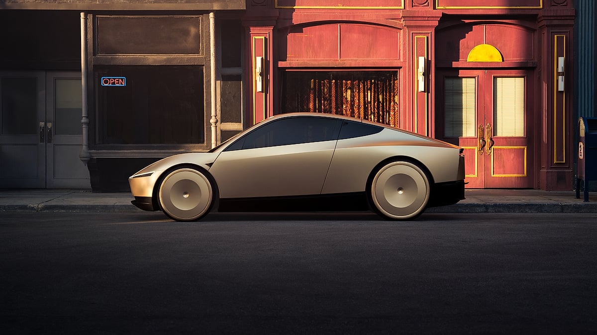 Side profile of Tesla Cybercab autonomous electric car parked in front of a red storefront
