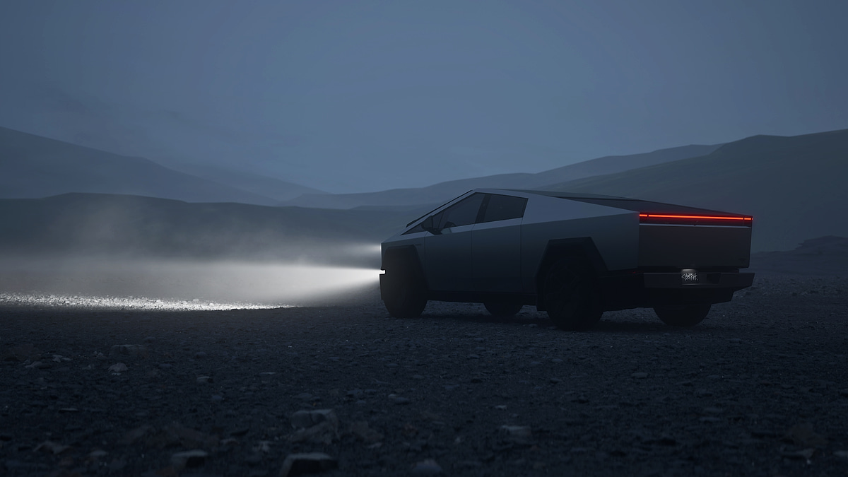 Tesla Cybertruck at night with headlights shining across a dark, foggy landscape.