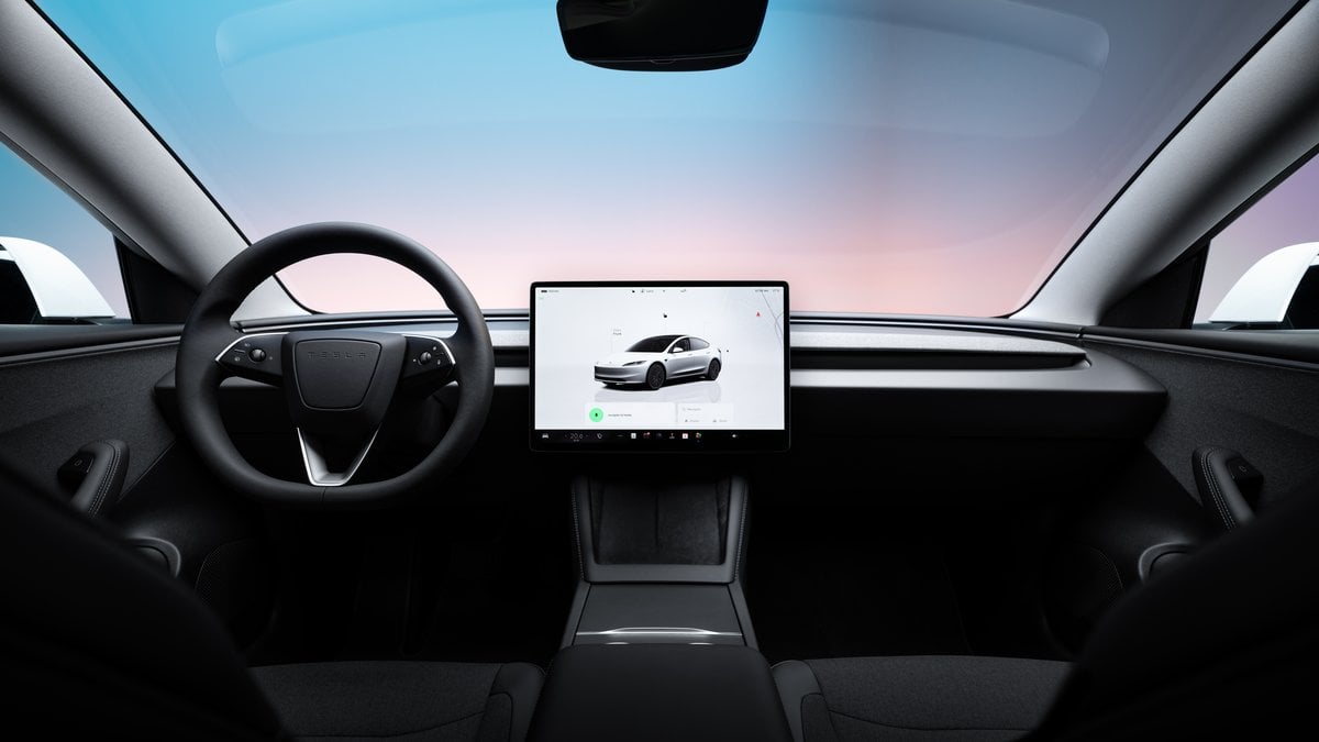 Tesla Model 3 interior featuring minimalist dashboard, steering wheel, and central touchscreen display.