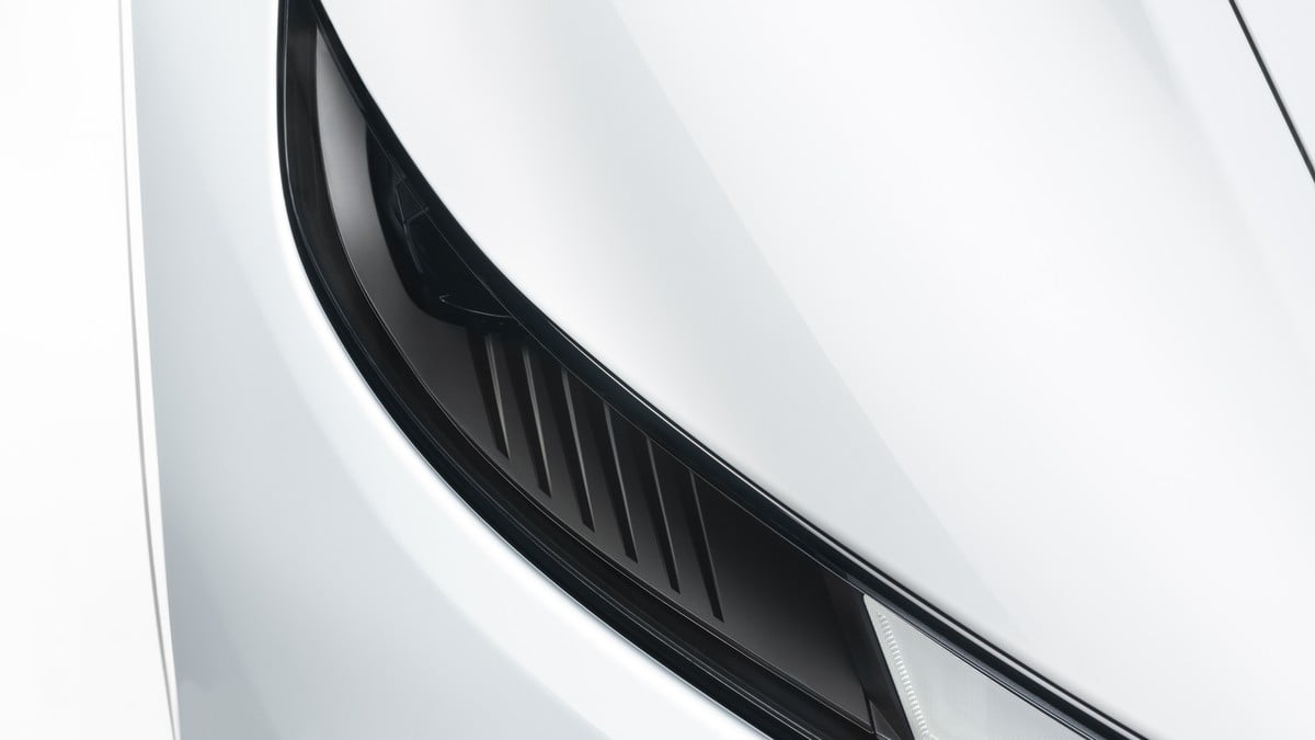 White Tesla Model Y electric SUV front view on a clean minimalist background