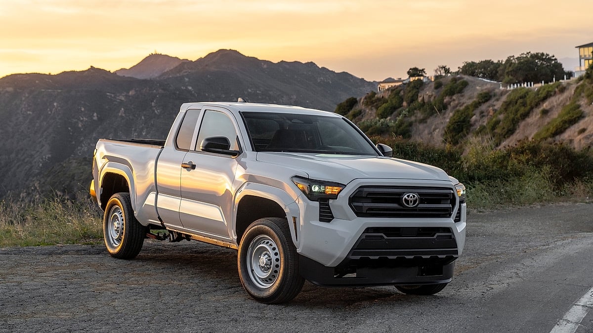 White Toyota Tacoma parked on mountain road at sunset