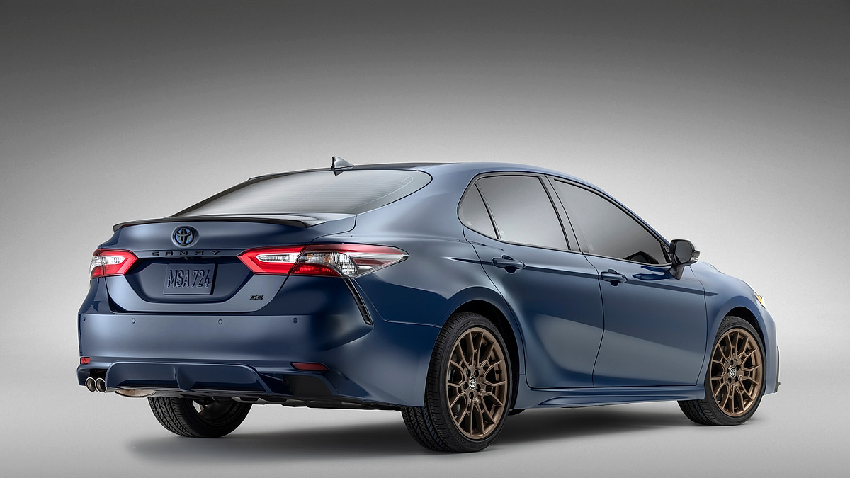 Blue Toyota Camry SE shown from the rear three-quarter angle in a studio setting.