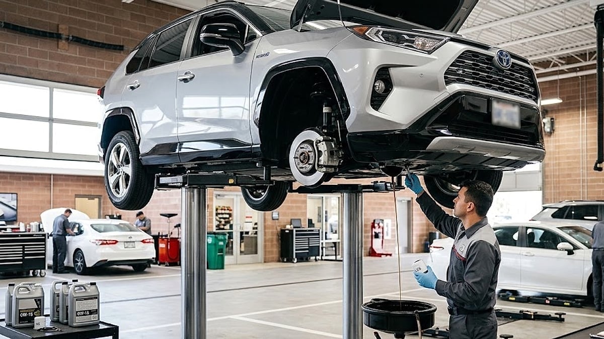 Toyota RAV4 undergoes a 0W-16 oil change in a dealership service bay while a mechanic prepares a fresh oil filter