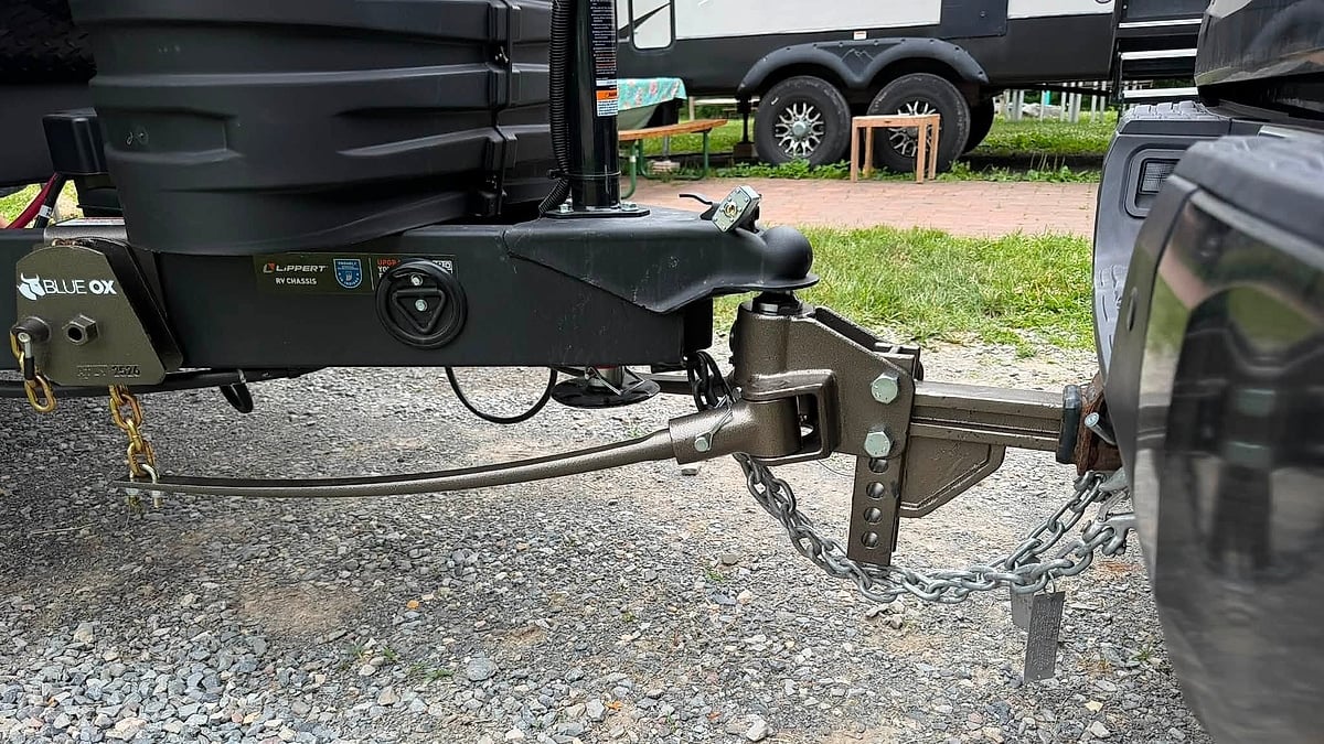 Close-up of a Toyota Tundra towing setup with a Blue Ox weight-distribution hitch connected to a NOBO travel trailer.