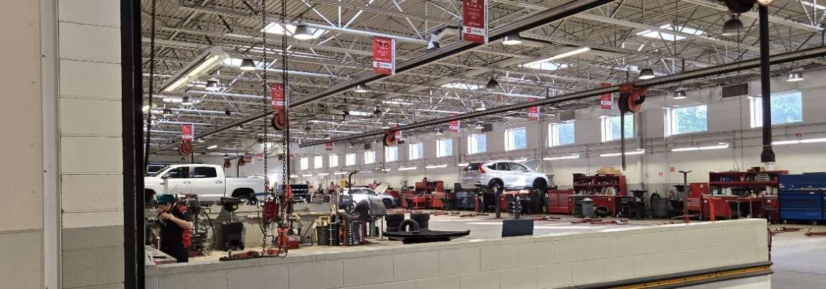 A Toyota dealer service area shows a Tundra having work performed